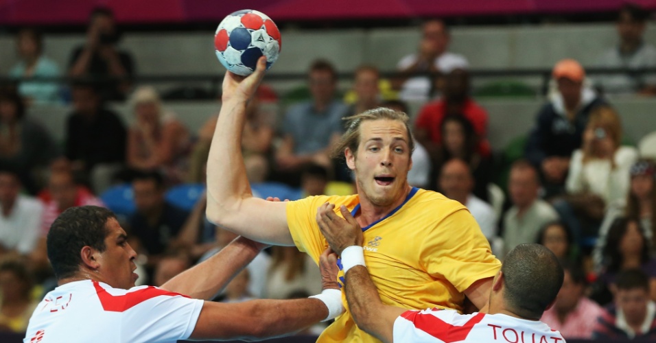Kim Ekdahl du Rietz, da Suécia, é agarrado por jogadores da Tunísia em partida neste domingo (29/07)