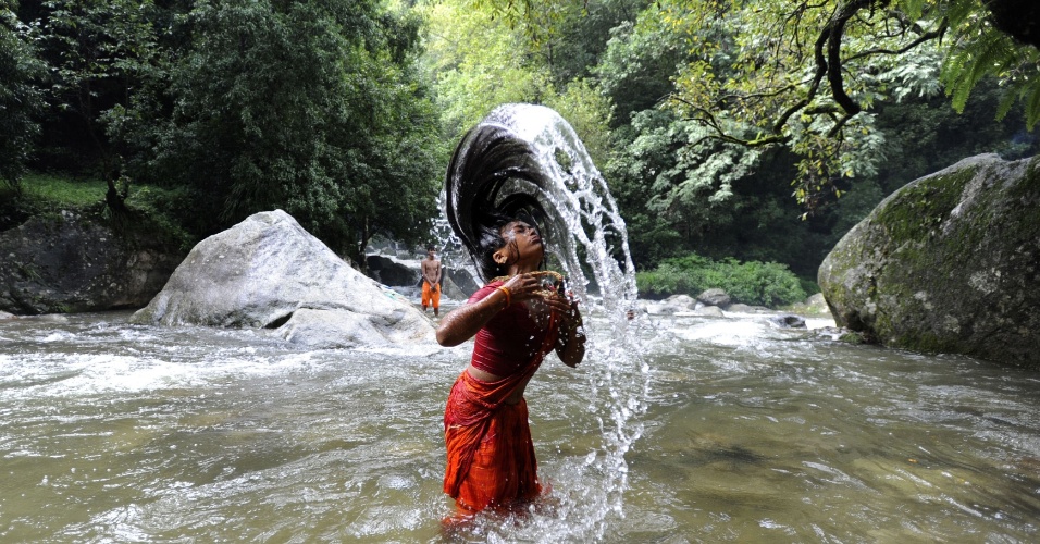30.jul.2012 Devota hindu toma um banho no rio Bagmati para as festividades Shravan antes de seguir em direção ao Templo Pashupatinath para oferecer orações ao Senhor Shiva (deus hindu da destruição), em Sundarijal nos arredores de Kathmandu, no Nepal