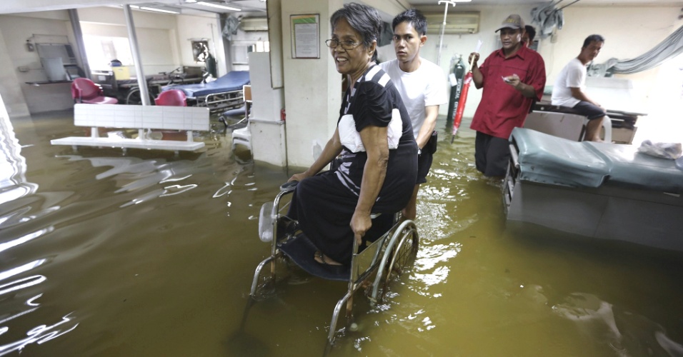 31.jul.2012 - Pacientes deixam hospital inundado de Valenzuela, ao norte da capital, Manila, nas Filipinas. As chuvas de monções castigam as regiões central e norte do paísk