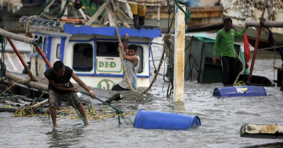 31.jul.2012 - Pescadores tentam resgatar seus pertences na baía de Manila, capital das Filipinas, depois da passagem da tempestade tropical Saola. As chuvas de monções já fizeram vítimas nas regiões central e norte do país