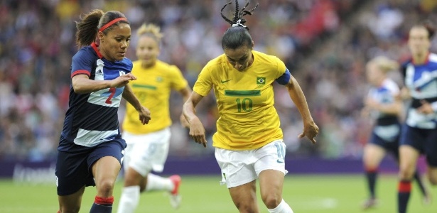 Marta, camisa 10 da seleção brasileira, conduz a bola cercada de perto pela britânica Alex Scott