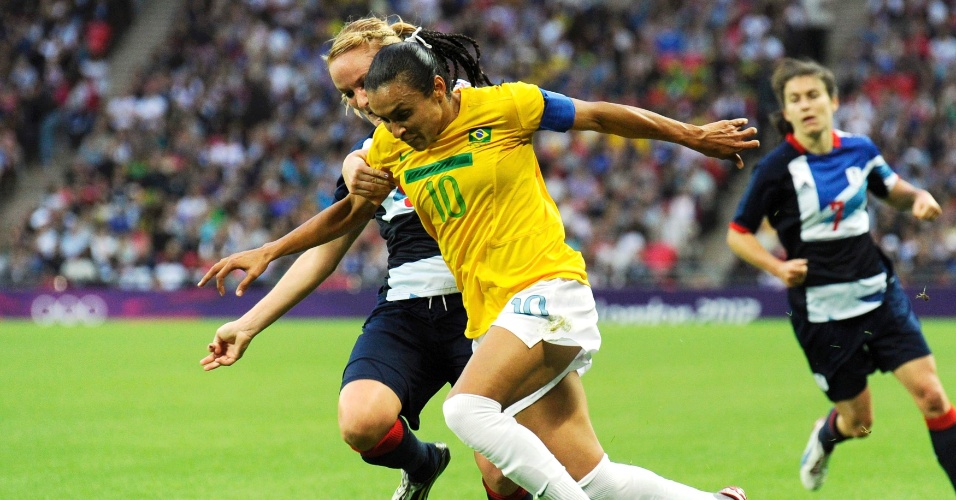 Marta tenta escapar da marcação de jogadora britânica na partida entre Brasil e Reino Unido no estádio Wembley