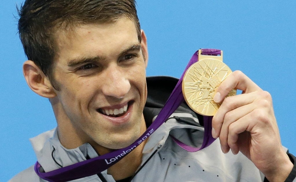 Michael Phelps comemora o ouro no revezamento 4x200 m livre; com a vitória, ele se tornou o recordista olímpico de medalhas