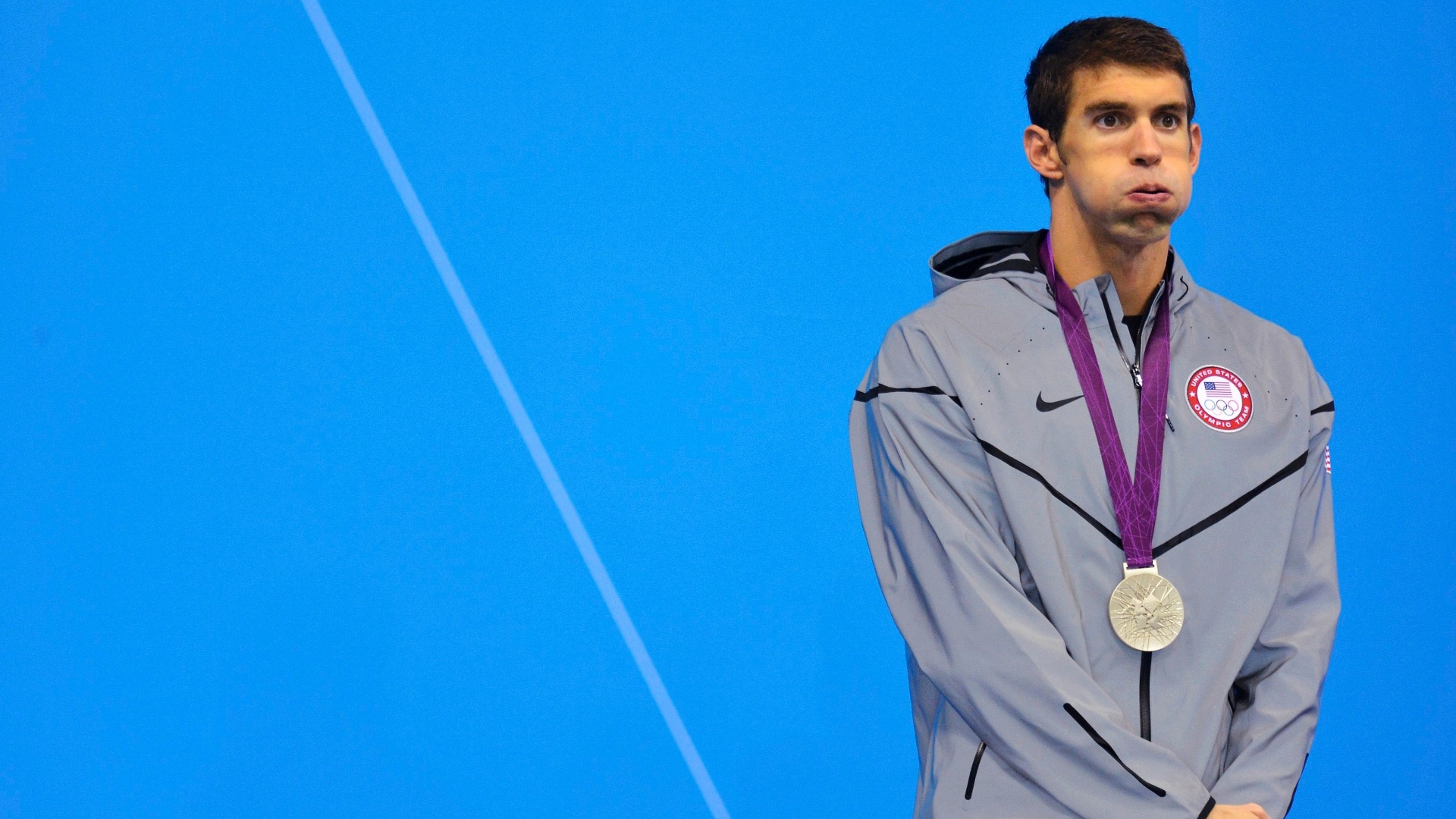 Michael Phelps parece cansado enquanto recebe a medalha de prata na natação