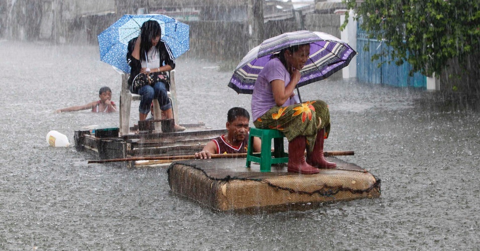 01.ago.2012 -  Moradores em balsas improvisadas enfrentam as inundações durante as fortes chuvas causadas pelo tufão Saola, em uma rua em Malabon, em Manila, nas Filipinas
