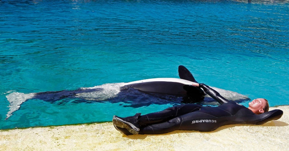 01.ago.2012 - Treinadora Amy Walton descansa junto com uma orca de 16 meses, no parque aquático Marineland, em Antibes, na França