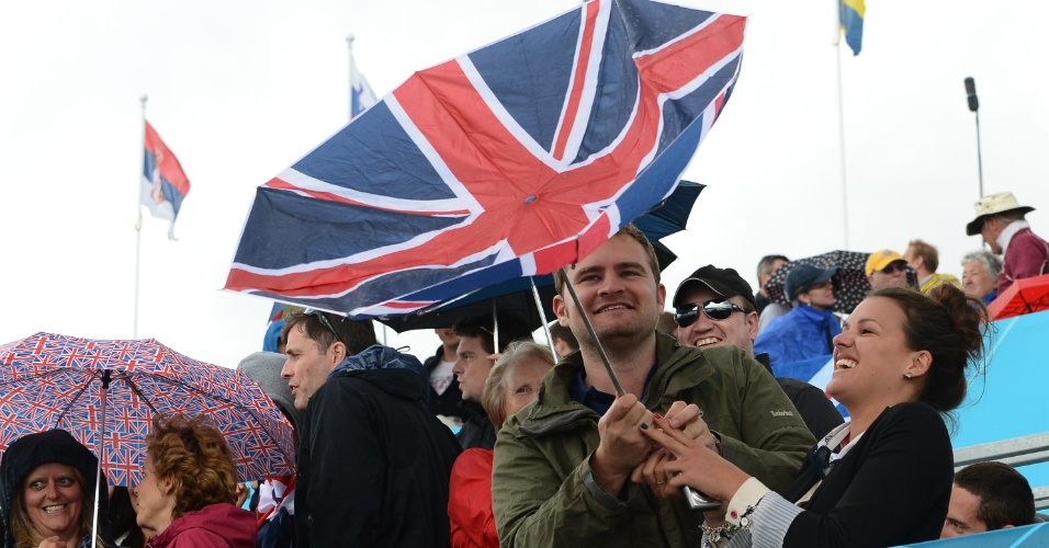 Torcedores britânicos brincam com guarda-chuva durante evento do remo