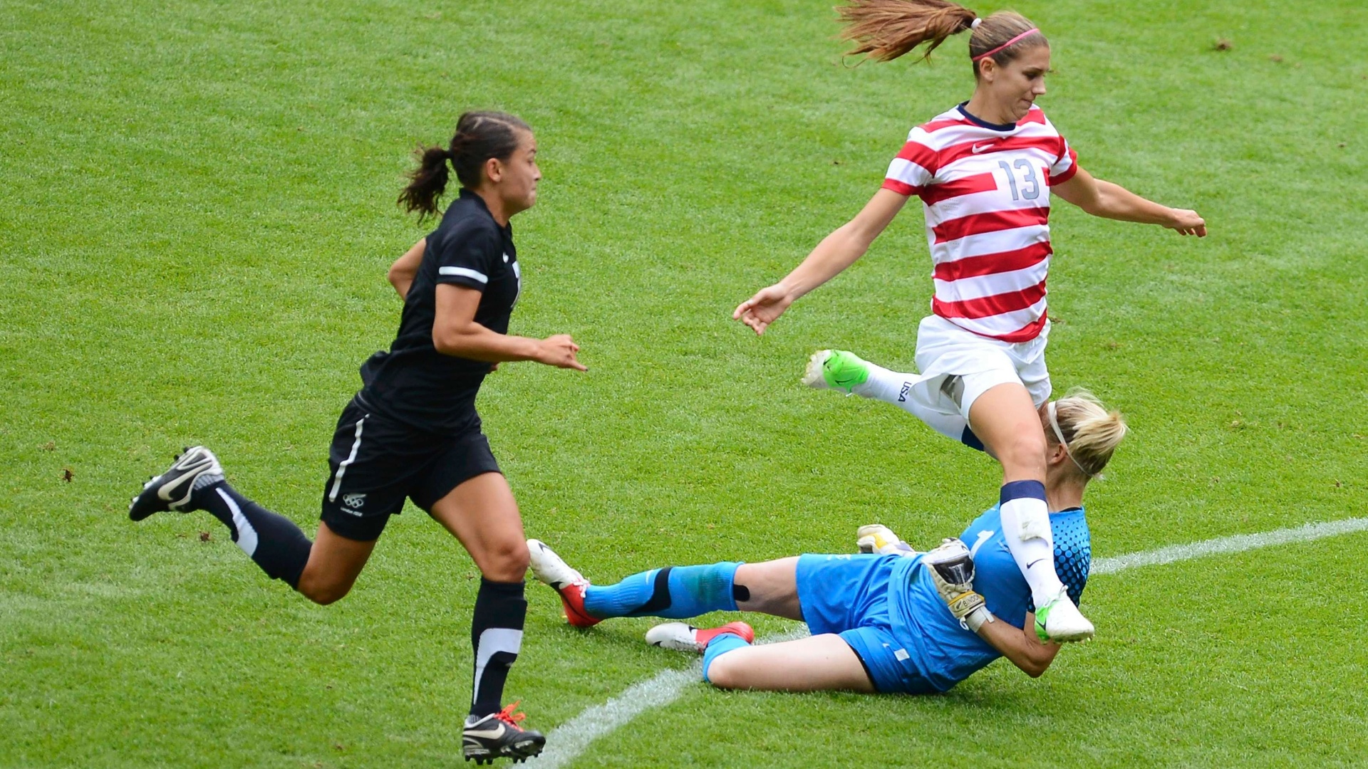03.ago.2012 - Alex Morgan, dos Estados Unidos, dá joelhada no rosto da goleira da Nova Zelândia, Jenny Bindon 