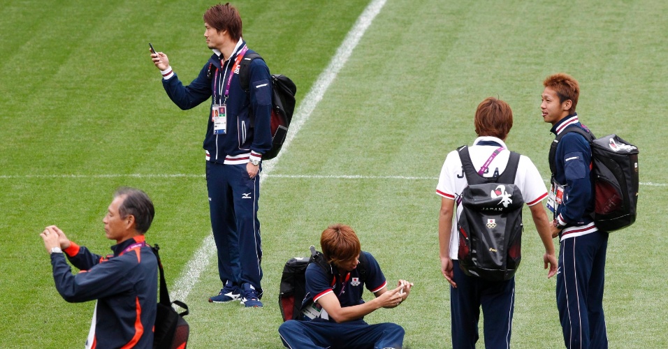 Atletas da seleção japonesa de futebol tiram fotografias do Old Trafford, em Manchester