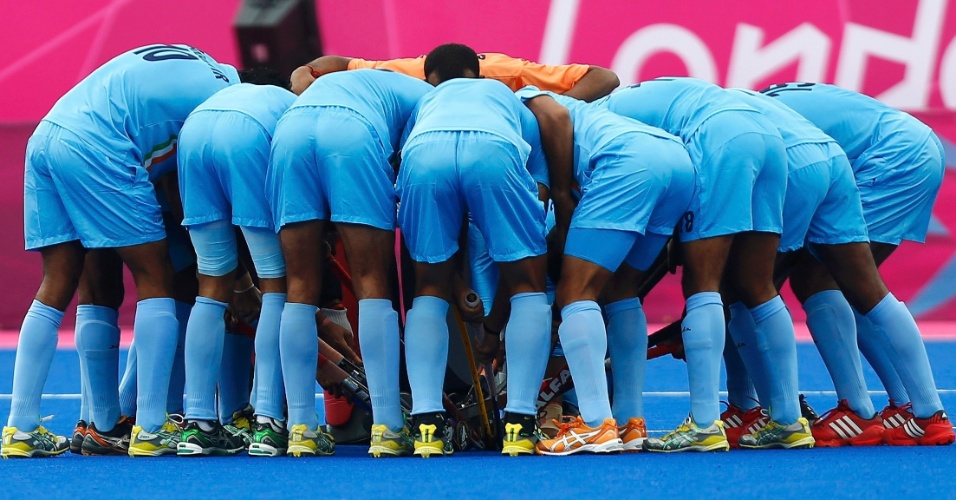 Jogadores da Índia se reúnem em campo antes do início da partida de hóquei na grama