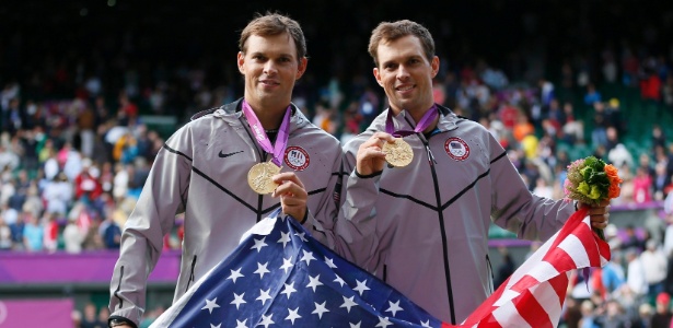 Com a bandeira dos Estados Unidos, irmãos Mike (e) e Bob Bryan mostram a medalha de ouro
