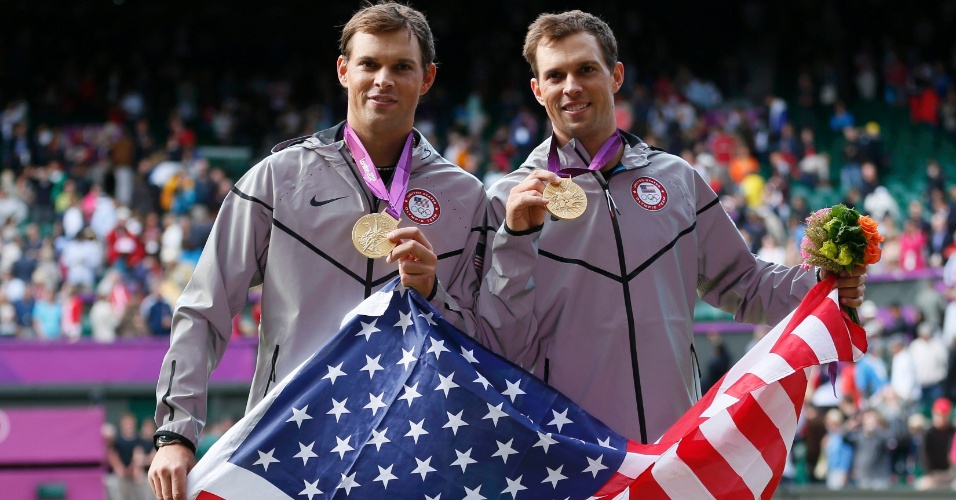 Com a bandeira dos Estados Unidos, irmãos Mike (e) e Bob Bryan mostram a medalha de ouro conquistada por eles na final masculina de duplas no tênis olímpico (04/08/2012)