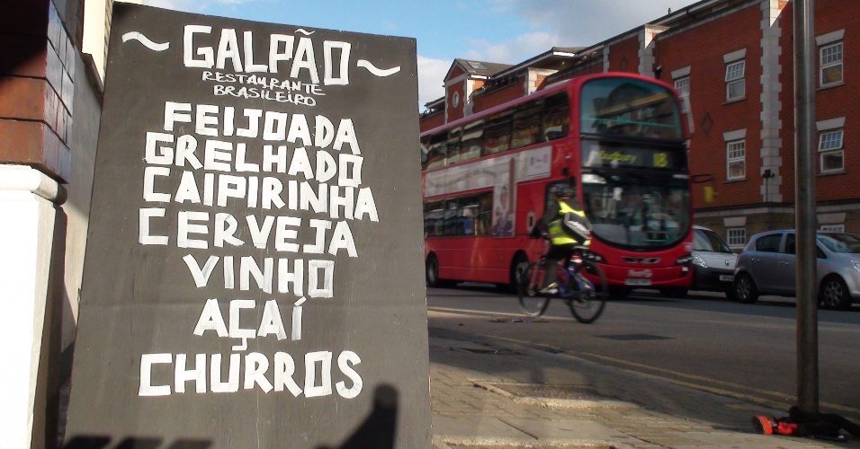 Lousa na rua anuncia comidas brasileiras para quem passa a Harrow Road, avenida com muito comércio da comunidade em Londres