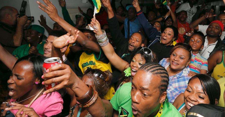 Espectadores da comunidade jamaicana em Brixton, ao sul de Londres, comemoram vitória de Usain Bolt na final olímpica dos 100 m rasos