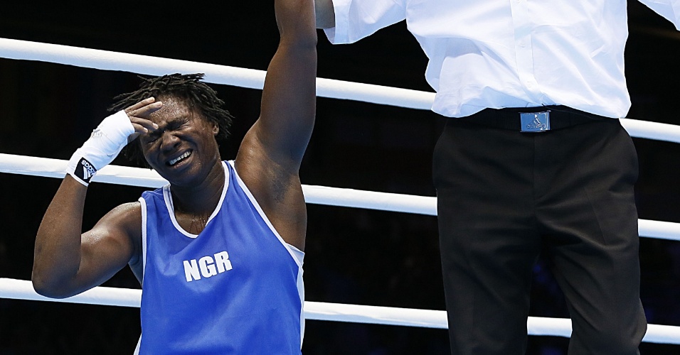 Nigeriana Edith Ogoke ajoelha após ser declarada vencedora da luta contra Elena Vystropova, do Azerbaijão, em luta válida de pesos médios