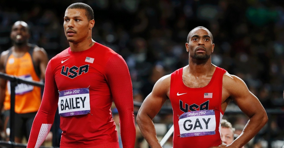 Ryan Bailey e Tyson Gay olham para telão após final olímpica dos 100 m rasos