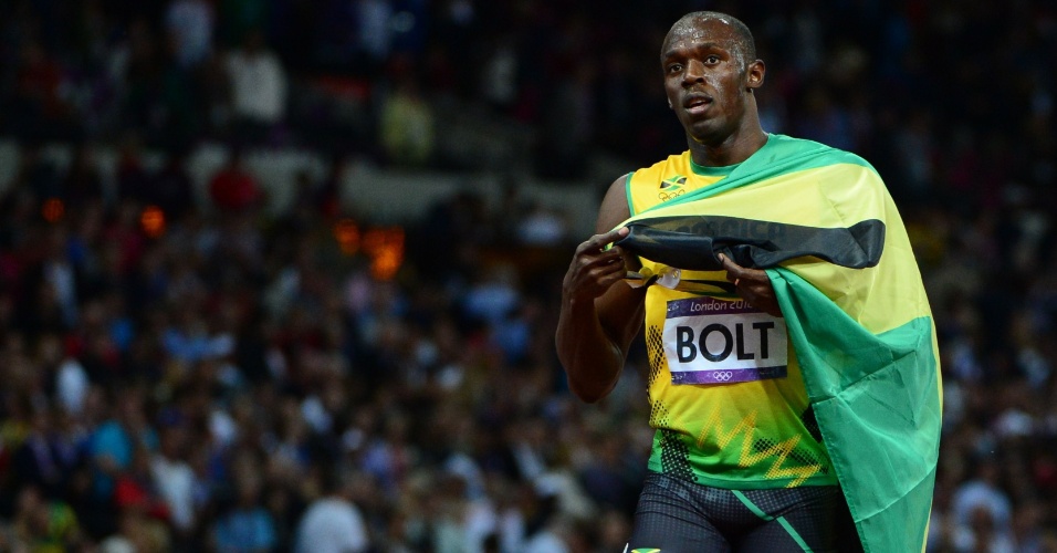 Usain Bolt carrega bandeira jamaicana após se tornar bicampeão olímpico dos 100 m rasos