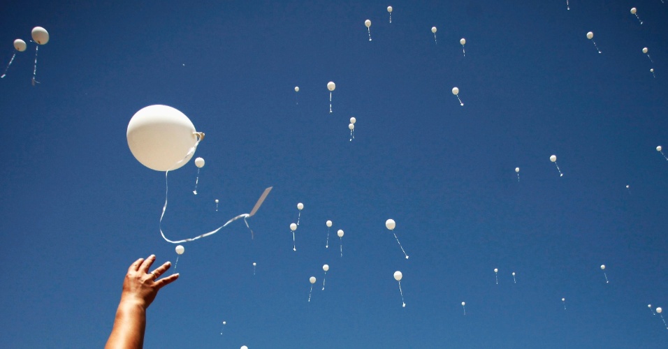 06.ago.2012 Mulher solta balão no ar com o nome de pessoas desaparecidas durante o 20º aniversário do fechamento do campo de detenção, em Omarska, na Bósnia e Herzegovina, onde 800 pessoas morreram durante a Guerra da Bósnia