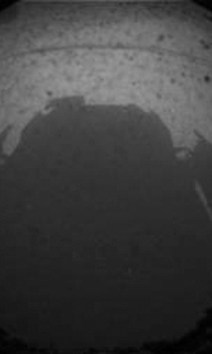 6.ago.2012 - As primeiras imagens enviadas pela "Curiosity" foram assim, em preto e branco. Na foto grande-angular, é possível ver a sombra do próprio jipe-robô, que tem como missão principal descobrir vestígios de vida no planeta vizinho