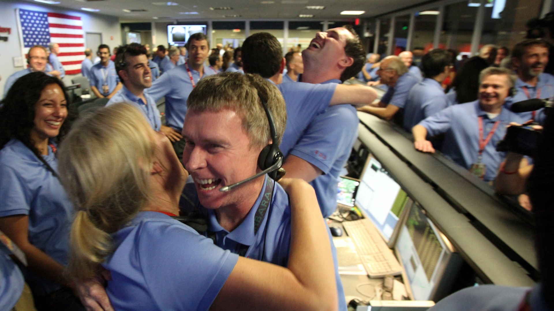 6.ago.2012 - O engenheiro de telecomunicações Peter Ilott abraça uma colega ao celebrar o pouso do robô Curiosity em uma cratera de Marte. A missão não tripulada estudará a possibilidade de ter havido vida no planeta vermelho - Brian van der Brug/AFP