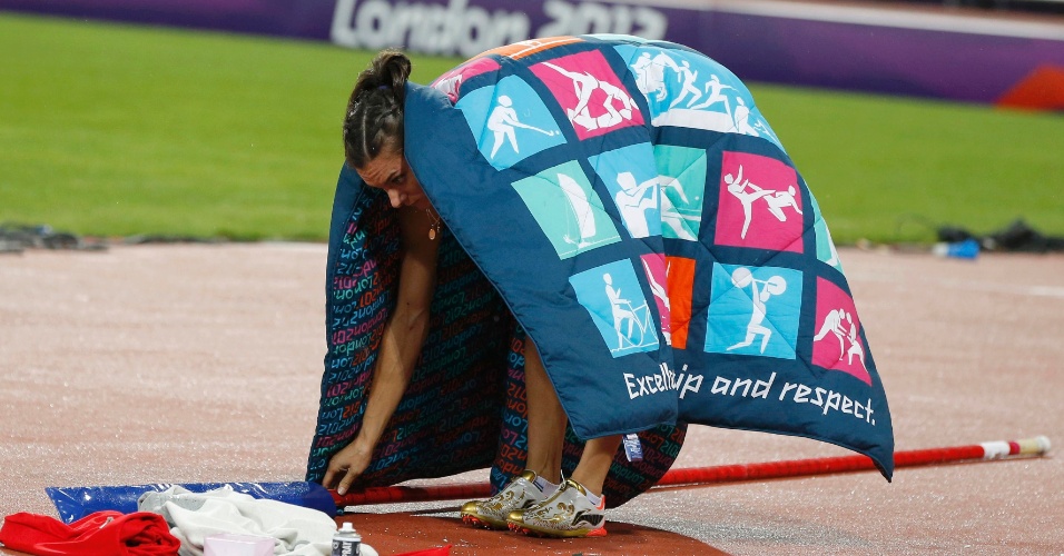 Após ficar fora da disputa pelo ouro, ussa Yelena Isinbayeva recolhe material utilizado na final olímpica do salto com vara