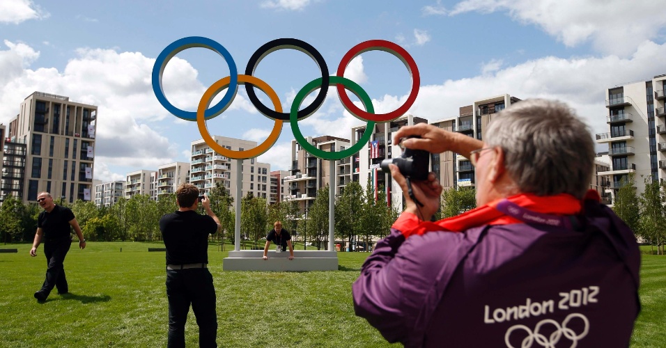 Voluntário tira fotografia dos anéis que simbolizam os Jogos na Vila Olímpica