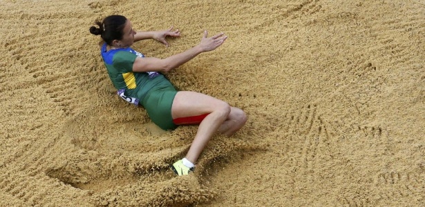 Maurren Maggi cai na caixa de areia após seu primeiro salto nas eliminatórias do salto em distância