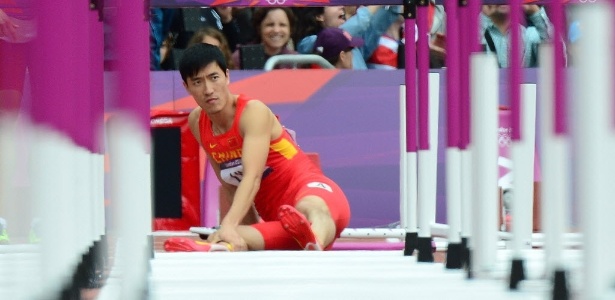 Chinês Liu Xiang sente o pé direito após queda na prova dos 110 m com barreiras