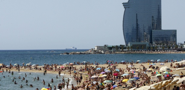 Espanhóis e turistas aproveitam um dia de calor na praia de Barceloneta - Julián Martín/EFE