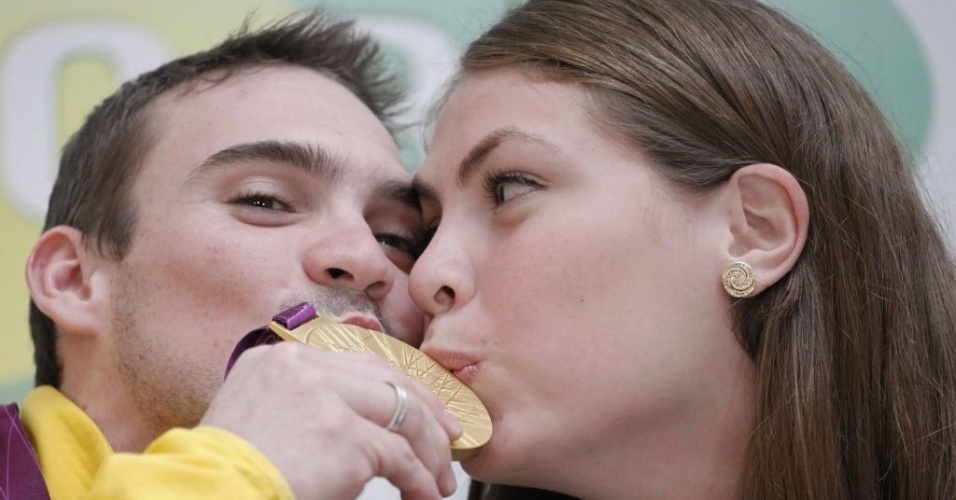 Arthur Zanetti e a namorada Juliana beijam a medalha durante entrevista coletiva realizada após à chegada em São Paulo