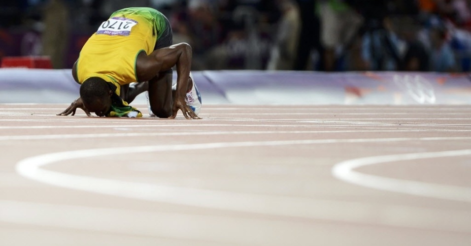 Usain Bolt beija o chão do Estádio Olímpico de Londres ao conquistar o bicampeonato olímpico dos 200 m 