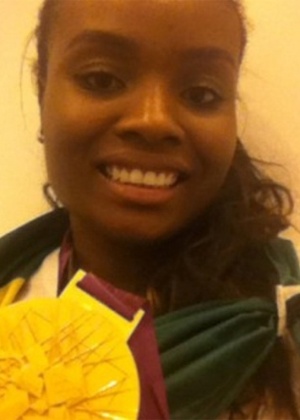 Fabiana mostra medalha de ouro conquistada no vôlei feminino, após vitória sobre os Estados Unidos