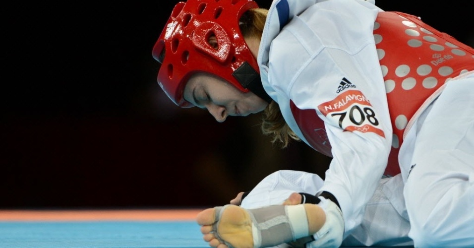 Natália Falavigna segura a perna durante o primeiro round da derrota para coreana na estreia do taekwondo