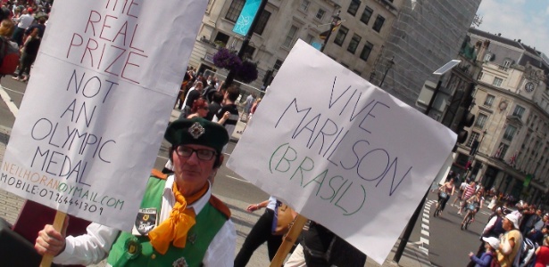 Ex-padre irlandês Cornelius "Neil Horan" segura cartazes de apoio ao brasileiro Marilson dos Santos 