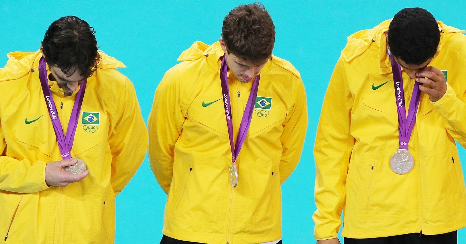 Jogadores brasileiros sobem cabisbaixos ao pódio para receber medalha de prata olímpica