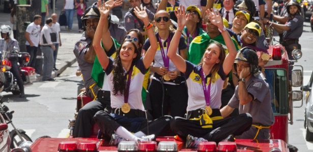 Jogadoras da seleção brasileira feminina de vôlei acenam para o público durante carreata em São Paulo