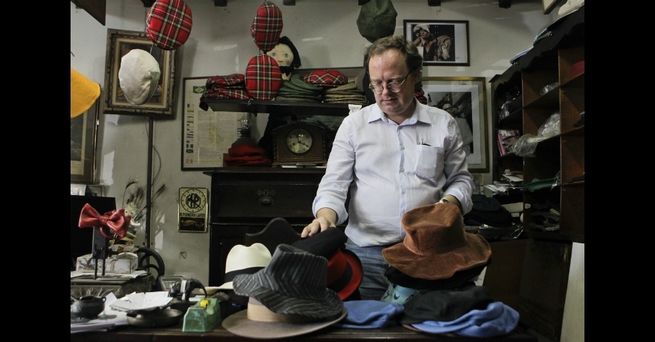 Maurício, um dos filhos de Plas, mostra chapéus vendidos no estabelecimento que existe há 58 anos em São Paulo  - Fernando Donasci/UOL 