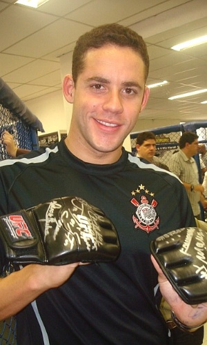 Thiago Pereira com luve autografada por Anderson Silva, na academia do Corinthians