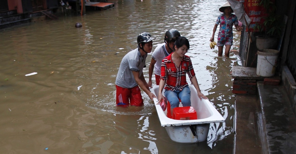 18.ago.2012 - Vietnamitas transformam banheira em barco para se atravessarem rua inundada em Hanói, no Vietnã. Pelo menos quatro pessoas morreram após a passagem da tempestade tropical "Kai-Tac", que levou inundações e fortes ventos ao norte do país