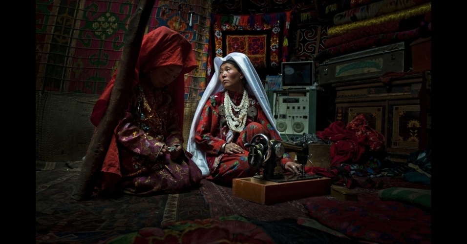 Cedric Houin, de Nova York, ganhou o primeiro lugar do concurso de fotos de viagem de 2012 da National Geographic com esta imagem de mãe e filha costurando. As tribos de etnia quirgiz vivem a 4,3 mil metros em uma das regiões mais remotas do Afeganistão, mas têm painéis solares, antenas parabólicas e celulares - Cedric Houin/National Geographic Traveler Photo Contest