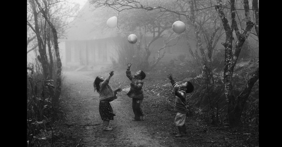 O segundo lugar ficou com Vo Anh Kiet, da Cidade de Ho Chi Minh, no Vietnã. A foto de janeiro mostra crianças da minoria étnica H'Mong brincando com balões na neblina de Moc Chau, na província de Ha Giang - Vo Anh Kiet/National Geographic Traveler Photo Contest