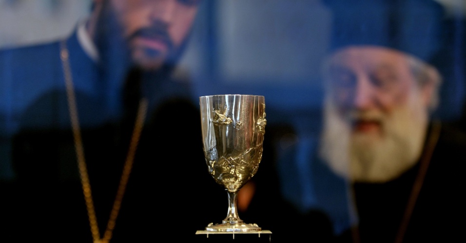 27.ago.2012 - Padres ortodoxos observam taça de prata entregue ao ganhador da maratona dos Jogos Olímpicos de 1896, exposta no museu de Acrópolis, em Atenas (Grécia)