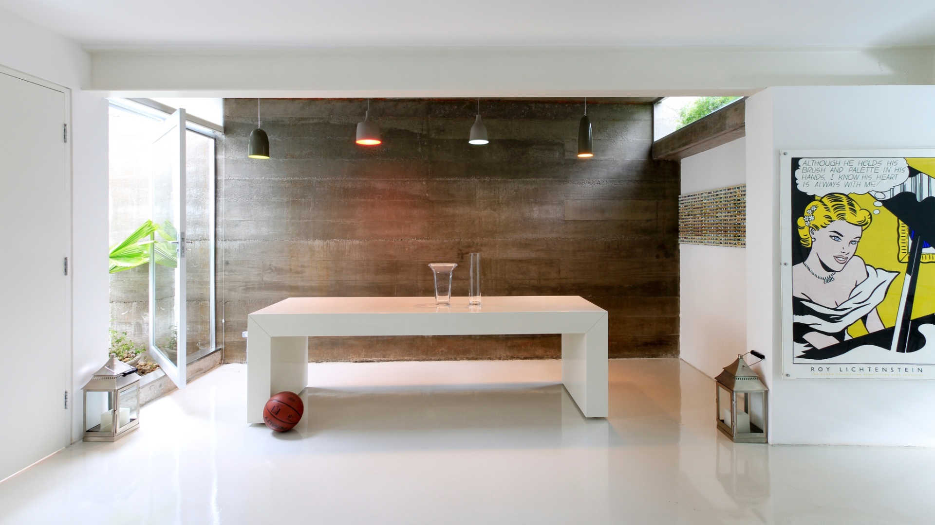 Onde fica hoje a mesa de jantar, havia um corredor externo lateral à Casa Cayowaa. Derrubada a antiga parede da sala (onde a viga branca, metálica, está exposta), criou-se o espaço limitado pelo concreto moldado "in loco", com espessura de 7 cm, a partir de fôrmas de madeira. Esse revestimento fica diretamente posicionado sobre a alvenaria do antigo muro lateral, já que a casa é a primeira de uma sequência de sobrados geminados de uma rua de Perdizes, em São Paulo - Tiago Andrade/ Divulgação