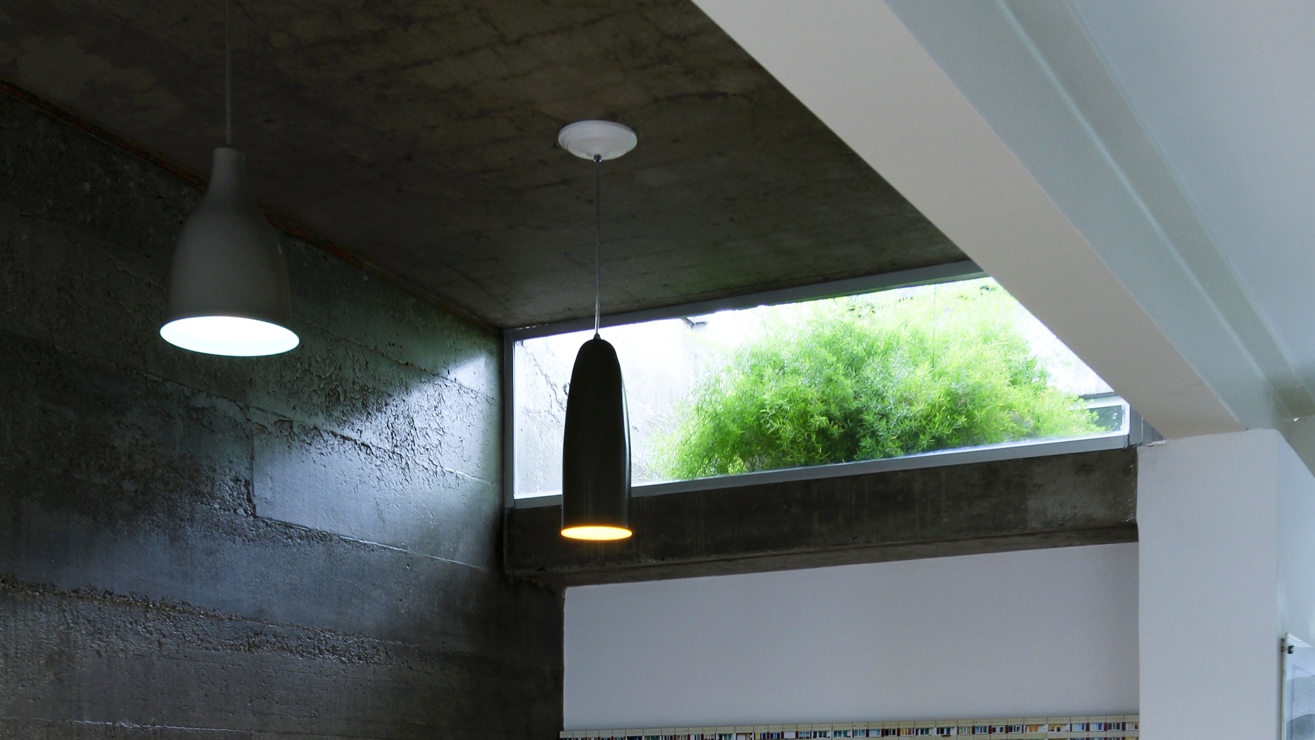 Para a nova sala de jantar, foi exigida uma extensão da laje original, sobre o antigo estar. Esses ambientes ficam separados apenas pela viga estrutural metálica branca, ainda exposta. A nova laje maciça, de concreto armado e moldada "in loco", só ganhou camada de verniz, sem qualquer outro revestimento para forro e manteve, assim, seu aspecto rústico, que ajuda a diferenciar o jantar do living. A reforma da Casa Cayowaa tem assinatura de Francisco Spadoni - Tiago Andrade/ Divulgação