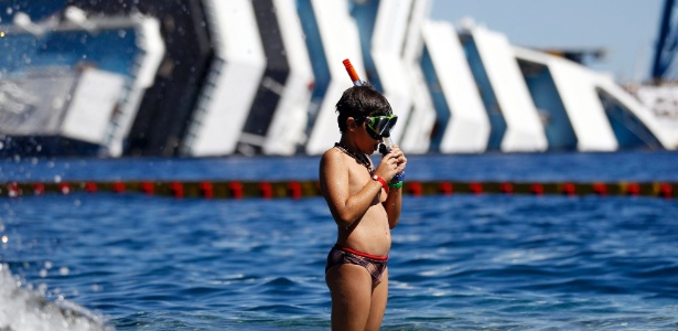 Garoto se prepara para mergulhar perto dos destroços do transatlântico Costa Concordia, na ilha Giglio, na Itália - Alessandro Bianchi/Reuters