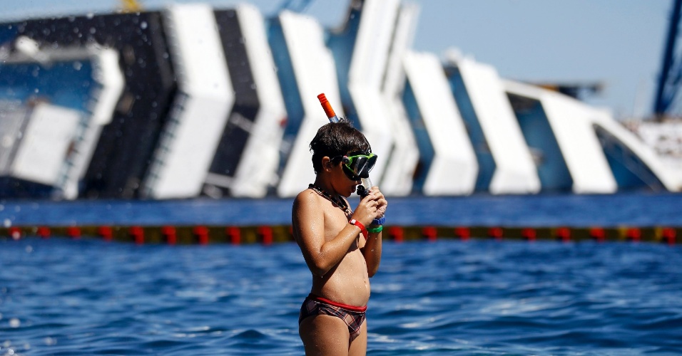 28.ago.2012 - Garoto se prepara para mergulhar perto dos destroços do transatlântico Costa Concordia, na ilha Giglio, na Itália