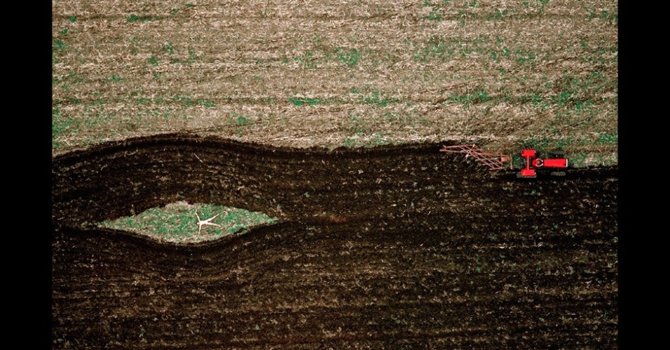 Para fazer a imagem acima, em um campo arado, o fotógrafo pediu emprestado um trator novo, procurou um pedaço de terra de cultivo plana e pediu ao dono do local que lhe permitisse manobrar ali dentro - John Crawford