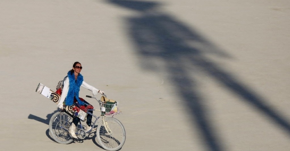 Ciclista pedala em frente a sombra do boneco de madeira que será queimado no último dia do Burning Man (29/8/12) - REUTERS/Jim Urquhart