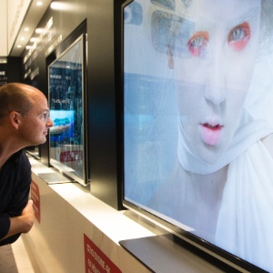 Homem verifica de perto qualidade de televisor durante evento de tecnologia em Berlim (Alemanha) - Markus Schreiber/AP - 30.ago.2012