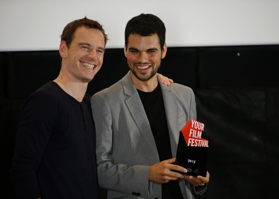 O ator Michael Fassbender e David Victori Blaya, da Espanha, vencedor do prêmio "Your Film Festival", promovido pelo You Tube, na 69ª edição do Festival de Veneza, em Veneza, Itália (2/09/2012) - AP Photo / Andrew Medichini